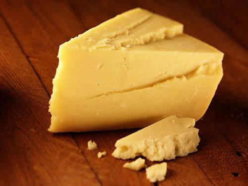 A piece of cheese on a wooden surface