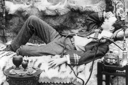 De Quincey resting on a couch with a hookah